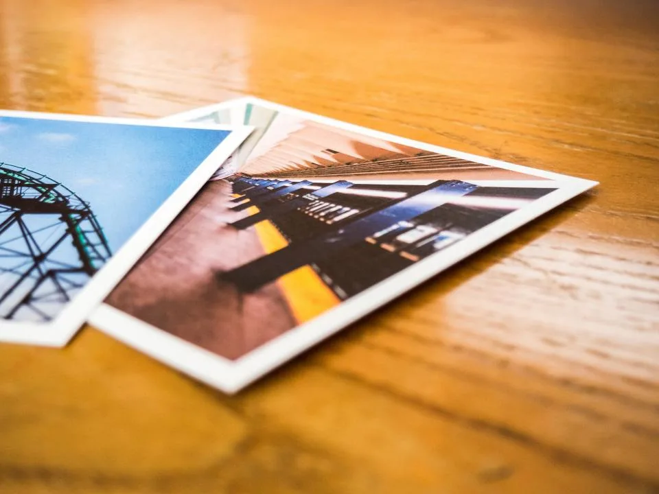 Printed photographs lying on a wooden table